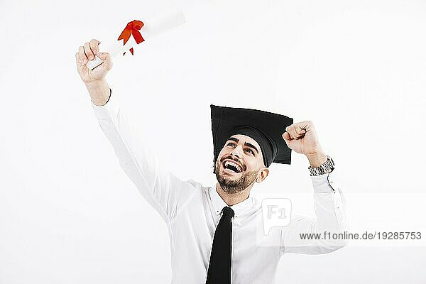 Glücklicher Mann mit akademischer Mütze und Diplom