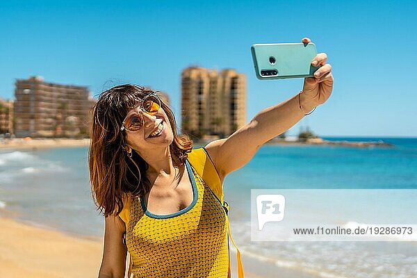 Ein junger ausländischer Tourist mit dem Telefon in Playa del Cura in der Küstenstadt Torrevieja  Alicante  Valencianische Gemeinschaft. Spanien  Mittelmeer