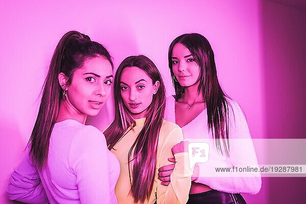 Lebensstil von Freunden  die in einem Nachtclub mit rosa Neonlicht feiern  Porträt einer jungen  schönen kaukasischen Frau  die in die Kamera schaut