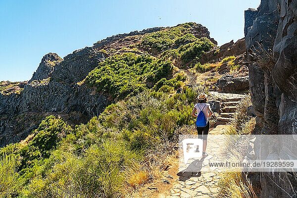 Eine junge Frau  die vom Aussichtspunkt Ninho da (Manta) in Richtung Pico do Arieiro spaziert  Madeira. Portugal