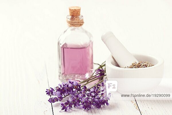 Lavendelbündel  ätherisches Öl und Trockenblumen in einem Mörser auf weißem Hintergrund. Spa und Wellness Einstellung