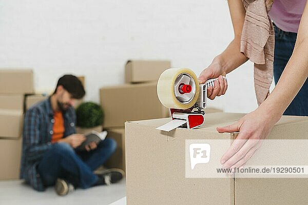 Packen von Kartons mit Klebeband  um eine neue Wohnung zu beziehen