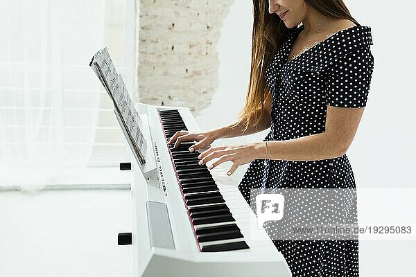 Close up lächelnde junge Frau spielt Klavier