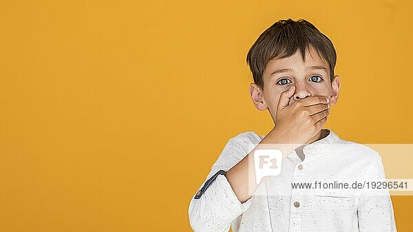 Kind bedeckt seinen Mund mit Kopierraum