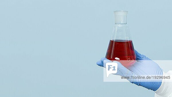 Vorderansicht eines Wissenschaftlers  der eine rote Chemikalie mit Kopierraum hält