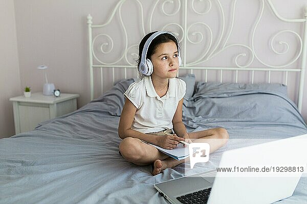 Hübsches kleines Mädchen benutzt ihren Laptop