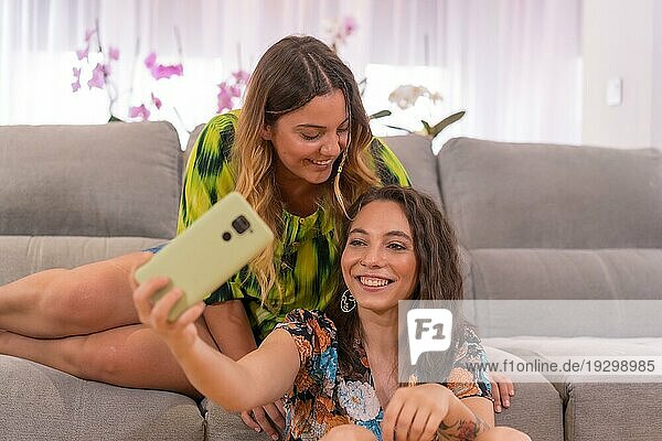 Ein lgbt Paar von kaukasischen Mädchen  die Spaß haben  ein Selfie mit dem Telefon auf dem Sofa zu Hause zu machen  lesbische Mädchen Beziehung