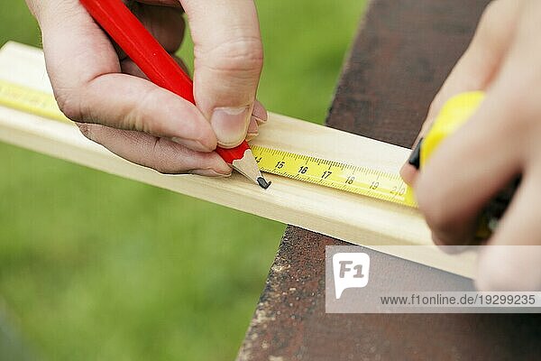 Nahaufnahme eines Zimmermanns  der 15 Zentimeter von einer Holzlatte im Freien entfernt ist