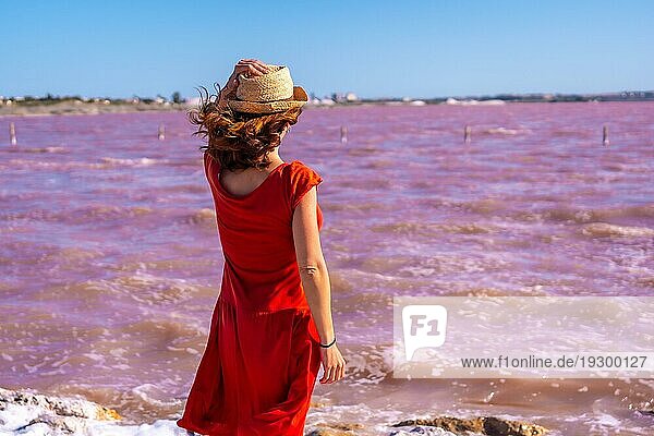 Mädchen mit rotem Kleid in der rosa Lagune von Torrevieja  Alicante. Gemeinschaft von Valencia. Spanien  Urlaub am Mittelmeer