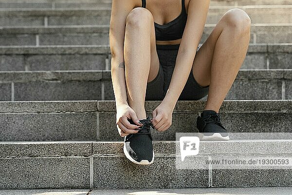 Vorderansicht Frau bindet ihre Schnürsenkel vor dem Sport