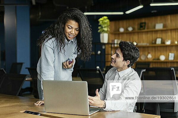 Coworker arbeiten zusammen im Büro mit Laptop