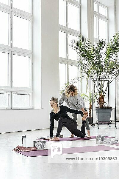 Frau übt Yoga mit Lehrer