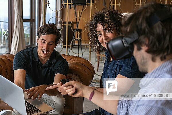 Nahaufnahme eines jungen Unternehmerteams  das einem Kunden ein neues Projekt in einem Virtual Reality Simulator in einer Hotelhalle vorstellt