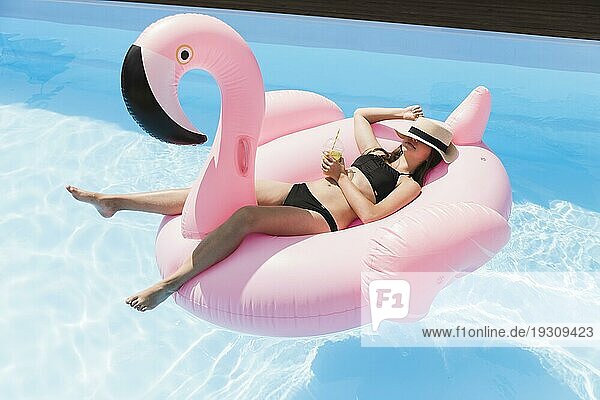 Long shot Mädchen legt Flamingo Floatie