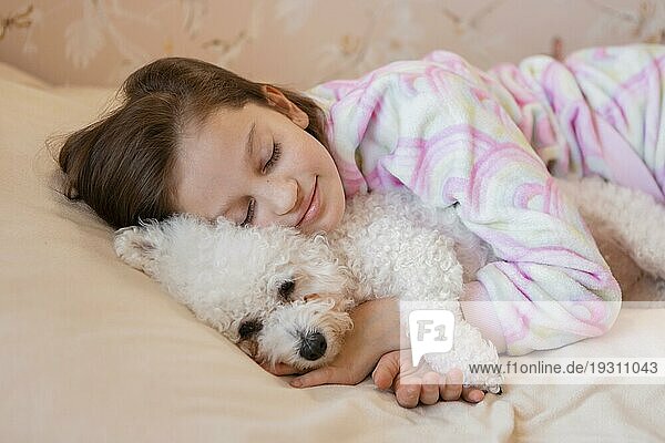 Mädchen umarmt ihr Hundebett beim Schlafen