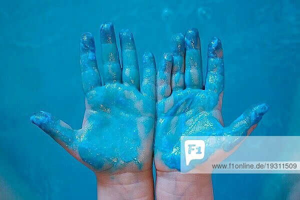 Blaue Farbe auf den blaün Händen der Kinder