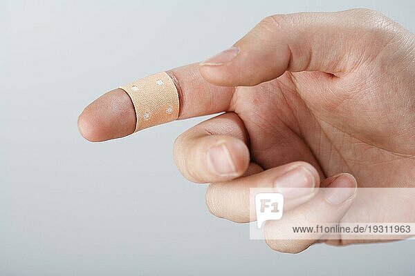 Ein Finger mit Textilklebeverband. Kurze Tiefenschärfe