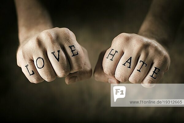 Mann mit (gefälschten) Love and Hate Tattoos auf seinen Händen