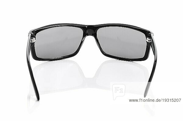 Eine hochwertige Sonnenbrille auf Weiß mit natürlicher Reflexion. Kurze Tiefenschärfe