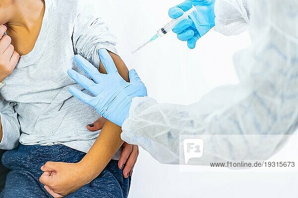 Eine Ärztin beruhigt das Kind zusammen mit seiner Mutter vor der Impfung. Impfung von Kindern. Impfung bei der Coronaviruspandemie Covid19