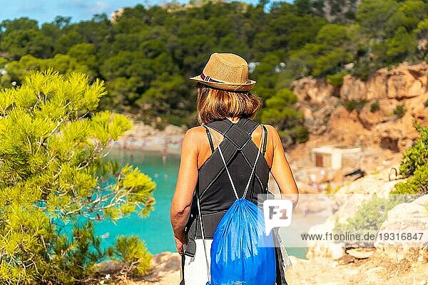 Urlaubskonzept  Ein Mädchen geht in Richtung Playa Salada und Saladeta an der Küste von Ibiza. Balearen