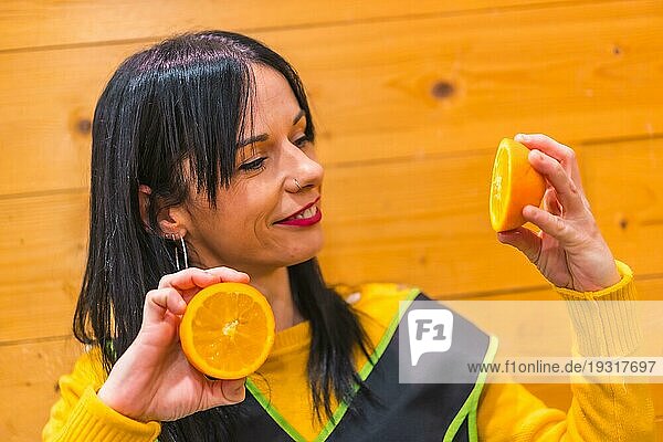 Spaß mit Orangen in der Hand eines brünetten kaukasischen Obstmädchens  das in einem Gemüseladen arbeitet