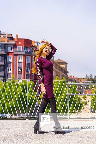 Schöne Frau in lila Kleid und schwarze Stiefel genießen in einem Park in der Stadt  posieren Blick in die Kamera