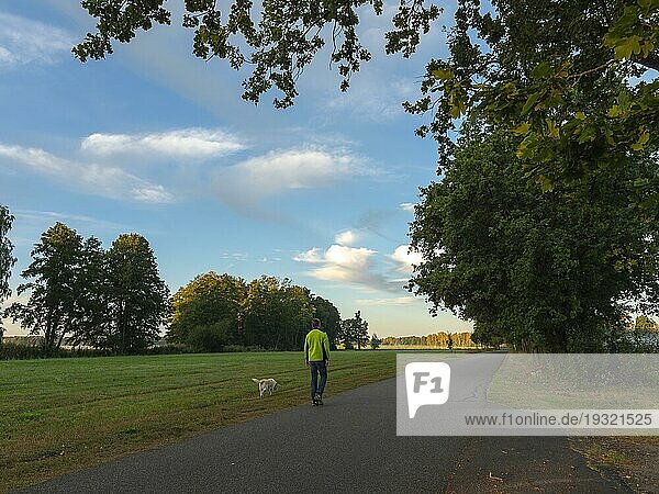 Spaziergänger mit Hund am Morgen  weite Auenlandschaft und Wiesen  Schlepzig  Spreewald  Brandenburg  Deutschland  Europa
