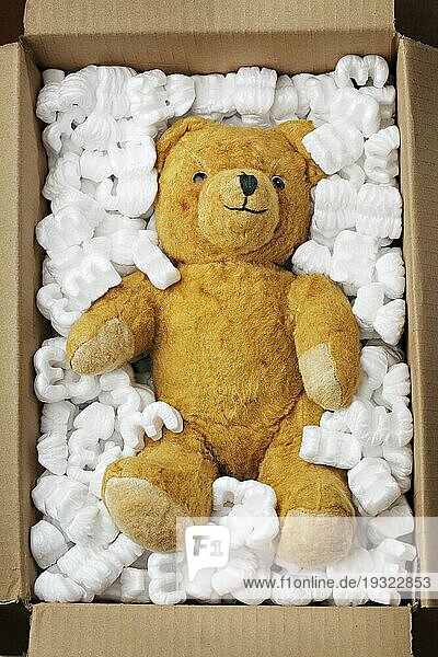 Alter Teddybär in einer Pappschachtel mit Styroporverpackung