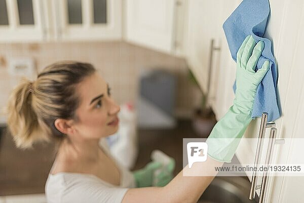 Seitenansicht Frau Reinigungsfläche mit Tuch Küche
