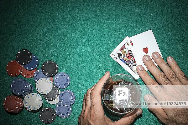 Pokerspieler zeigt Bube Ass Karte mit Casinochips grünen Pokertisch