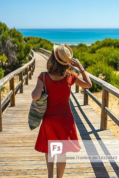 Ein junges Mädchen auf dem Holzweg zum Playa Moncayo in Guardamar del Segura bei Torrevieja  Alicante. Gemeinschaft Valencia. Spanien