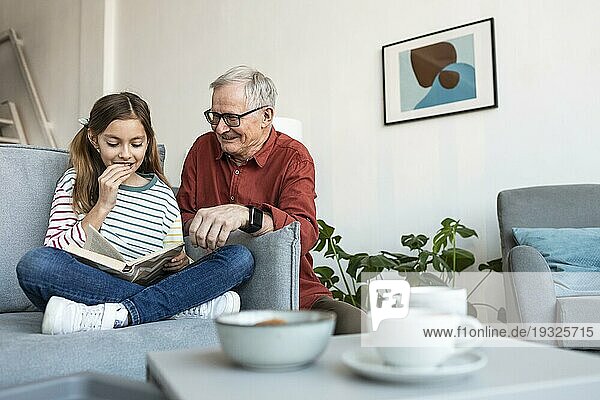 Großvater und Mädchen lesen zusammen