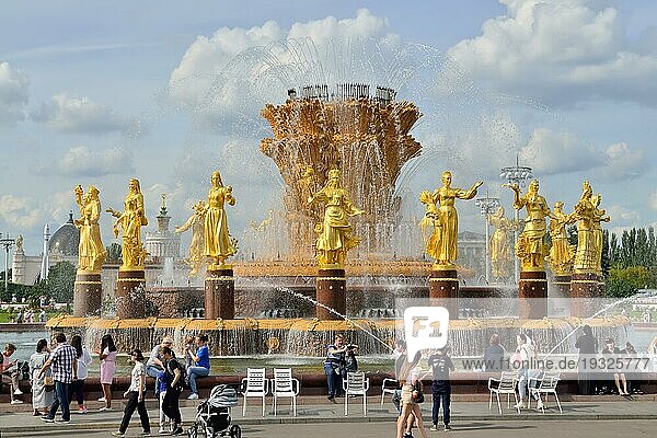 Moskau  Russland  25. August 2020: Touristen spazieren in der Nähe des BrunnensFreundschaft der Völker mit goldenen Statuen  dem Hauptbrunnen und einem der wichtigsten Symbole der VDNH  Europa