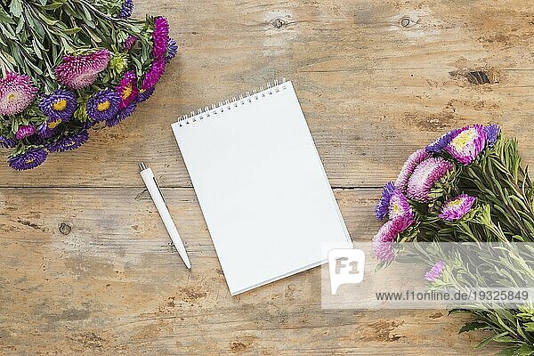 Hohe Winkel Ansicht Spirale Notizblock Stift Bouquet Blumen aus Holz Schreibtisch