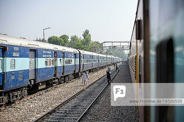 Jodhpur  Indien  10. Dezember 2019: Menschen auf den Bahngleisen zwischen zwei geparkten Zügen am Bahnhof von Jpdphur  Asien