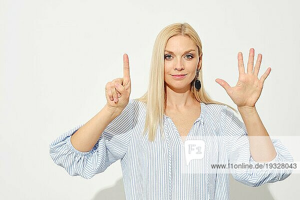 Attraktive blonde Frau zeigt sechs Finger. Zählen mit Fingern