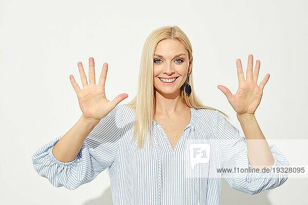 Attraktive blonde Frau zeigt zehn Finger. Zählen mit Fingern