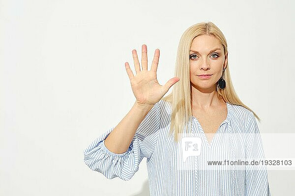 Attraktive blonde Frau zeigt fünf Finger. Zählen mit Fingern