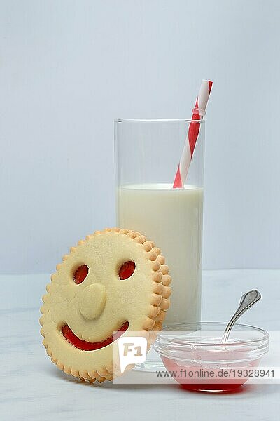 Gebäck mit Smiley-Gesicht und Glas Milch