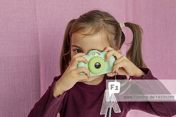 Portrait kleines Mädchen spielt mit Kamera