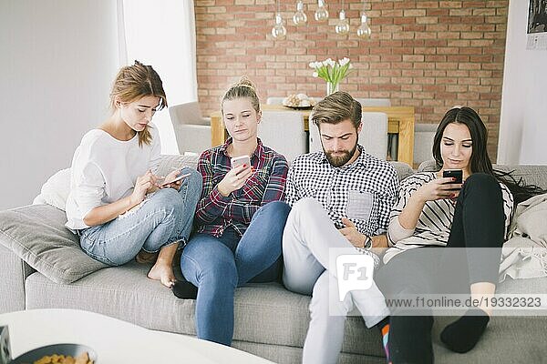 Menschen mit Gadgets auf dem Sofa gruppieren
