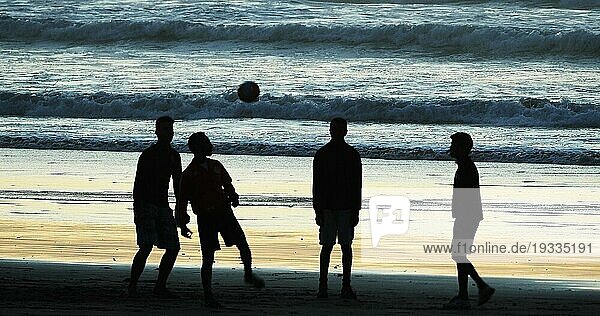Eine Gruppe von Menschen spielt Fußball am Strand von Cabourg bei Sonnenuntergang  Normandie