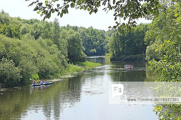 Eine Gruppe von Menschen fährt mit Kajaks einen schönen Fluss entlang. Sommerferien. Sport und Erholung auf dem Fluss im Sommer. Kajakfahren auf dem Fluss. Freunde verbringen Zeit zusammen Segeln im Fluss