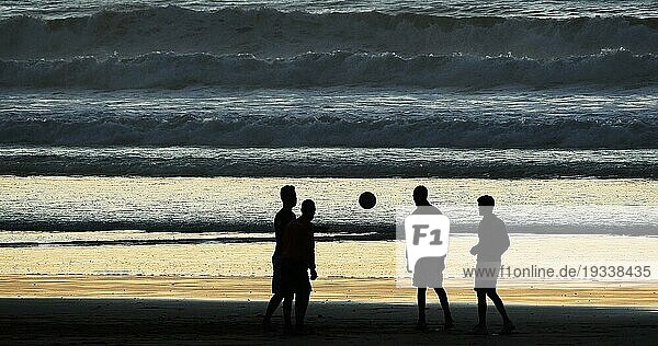 Eine Gruppe von Menschen spielt Fußball am Strand von Cabourg bei Sonnenuntergang  Normandie
