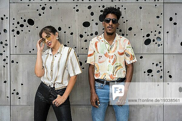 Zwei multiethnische junge  modische Menschen posieren auf der Straße