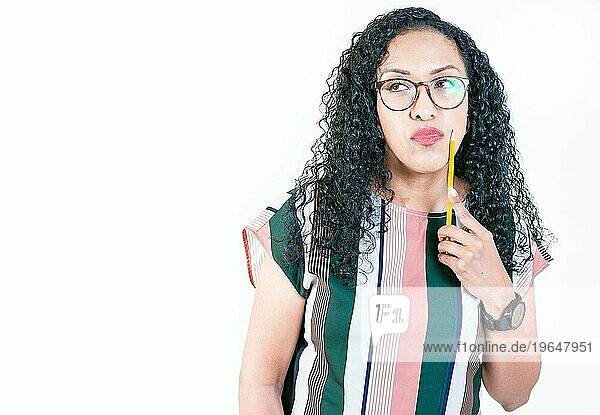Nachdenkliche junge Frau mit Brille hält einen Bleistift. Afro Mädchen denkt und hält Bleistift am Kinn