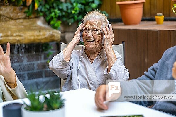 Glückliche Senioren mit Kopfhörern und viel Spaß in einem Pflegeheim