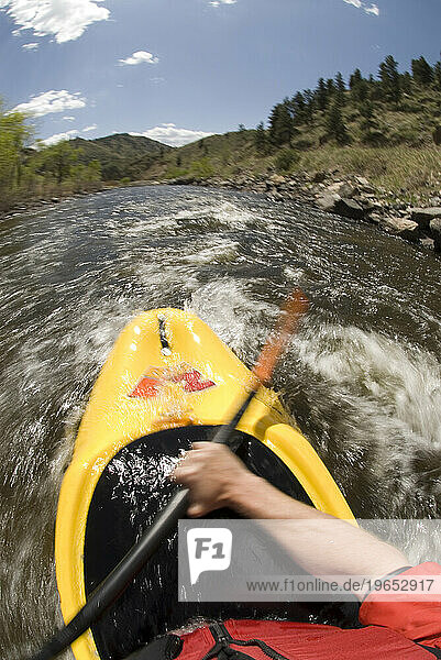 A man kayaking on the Cache La Poudre River  Fort Collins  Colorado.