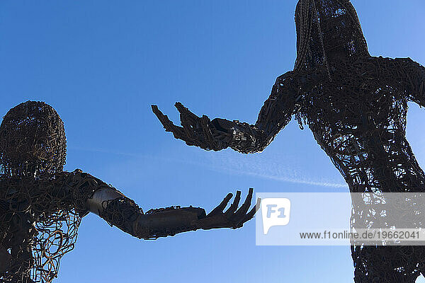 Metal sculpture of two people.